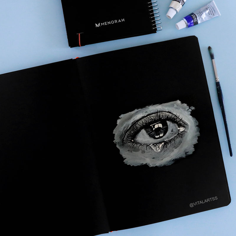 Eye with teardrop acrylic painting in 250 GSM black sketchbook, Portrait sketchbook, Menorah sketchbook.