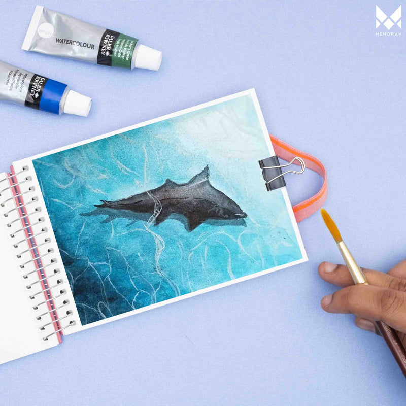 Shark watercolor painting on A6 size watercolor sketchbook is the best travel accompanion for the creators. Watercolor sketchbook is made of 100% cotton and is 100% Vegan. It contains 40 pages with a 300GSM Thickness so that watercolor won't penetrate to the other page. It is covered by Metal spiral with 360 Degree easy turn. Make your creations by using watercolour paintings, Acrylics, Gouache, Tempera, Poster colour in this sketchbook. Bright Blue color sketchbook
